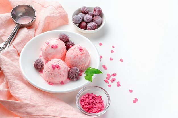 Chilled berry-cream dessert on a light wall. Cherry ice cream with berries and mint.