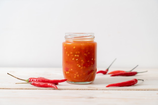 chilli or chilli sauce in bottle and jar on wood