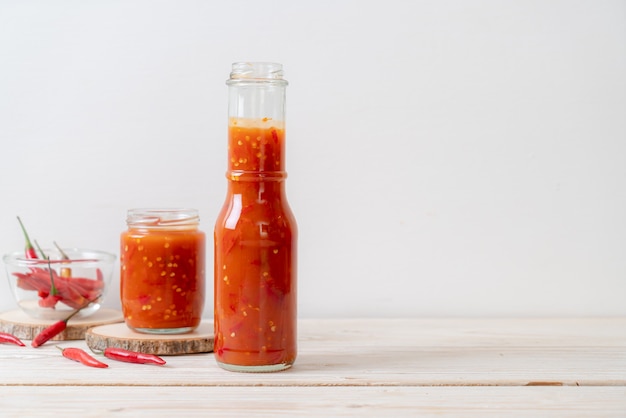 chilli or chilli sauce in bottle and jar on wwod