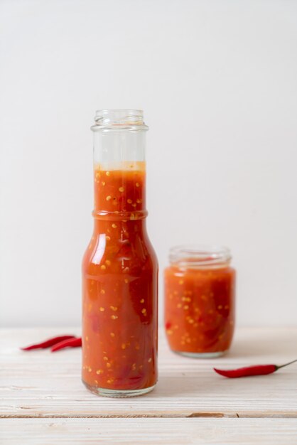 Peperoncino o salsa di peperoncino in bottiglia e vaso su wwod