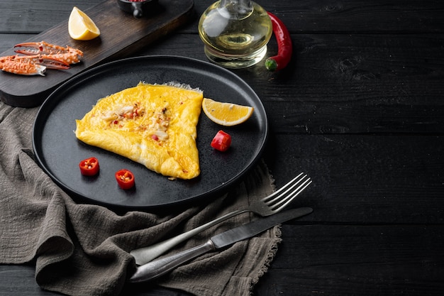 검은 나무 테이블 배경에 접시에 칠리 크랩 부드러운 omlette