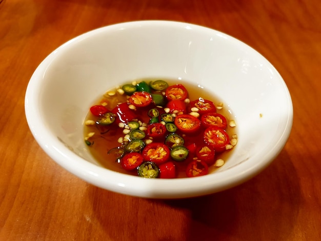 Foto salsa di soia al peperoncino su un tavolo di legno.