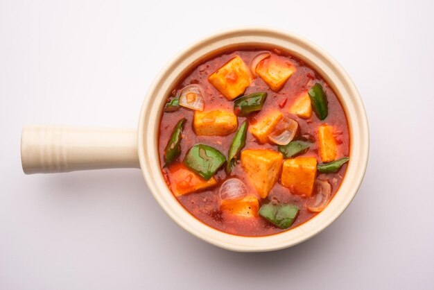 Photo chilli paneer or spicy cottage cheese served in bowl with capsicum and onion favorite indian starter