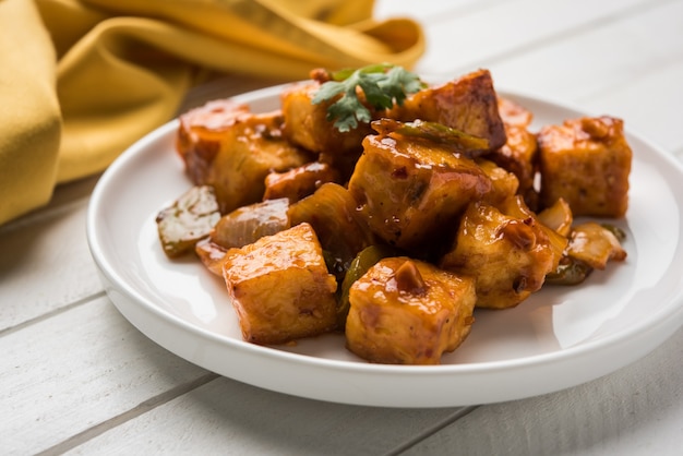 칠리 파니르 또는 매운 코티지 치즈, 흰색 접시에 고추와 양파, 좋아하는 인도 스타터 메뉴, 선별적인 포커스 제공