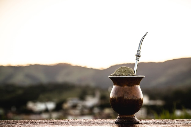 Chimarrao gourd with a small town from Rio Grande do Sul in the background infusion of yerba mate