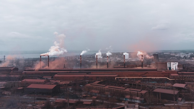 Un impianto chimico di canna fumaria nello scarico di tubazioni industriali inquinanti inquina l'atmosfera con