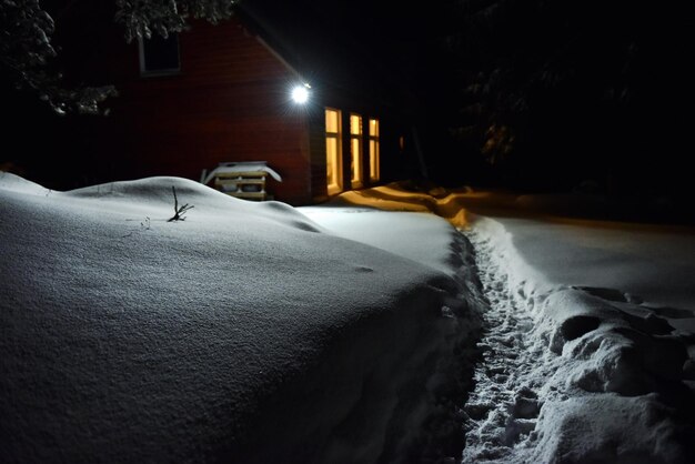 Chimney light of a cottage illuminate the snow outside at winter