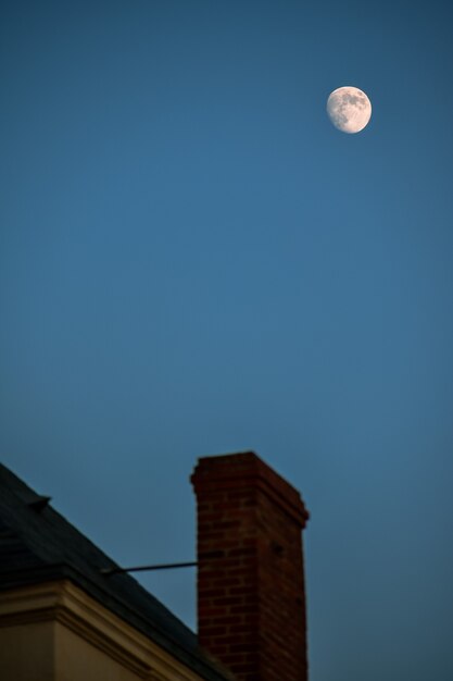 Camino e tetto sfocati, con la luna