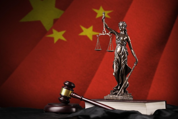 China flag with statue of lady justice constitution and judge hammer on black drapery Concept of judgement and guilt