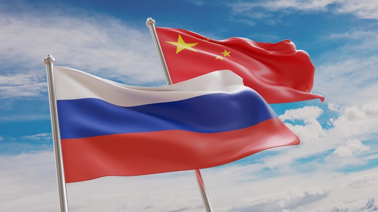 Китай и Россия Китайские и российские флаги размахивают на голубом небе