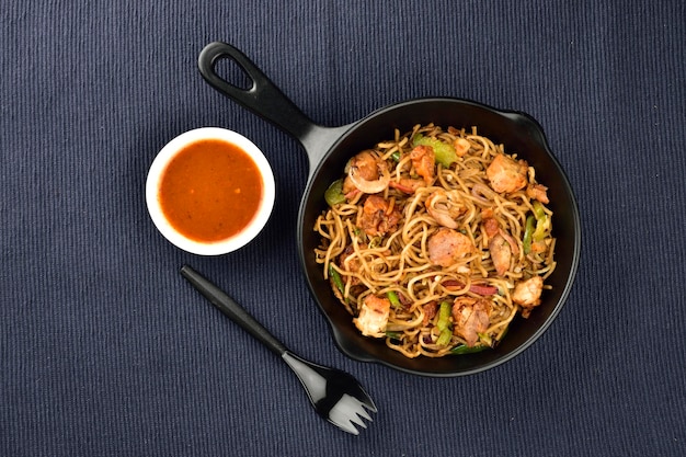 Chinees eten kip chowmein met saus op katoenen placemat