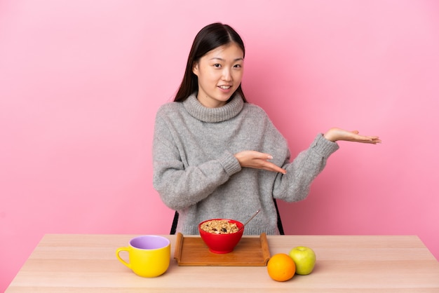 Chinees meisje zittend aan een tafel en ontbijten