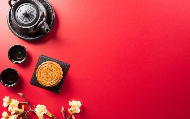 Chinees MidAutumn Festival-concept gemaakt van mooncakes-thee en pruimenbloesem op rode achtergrond