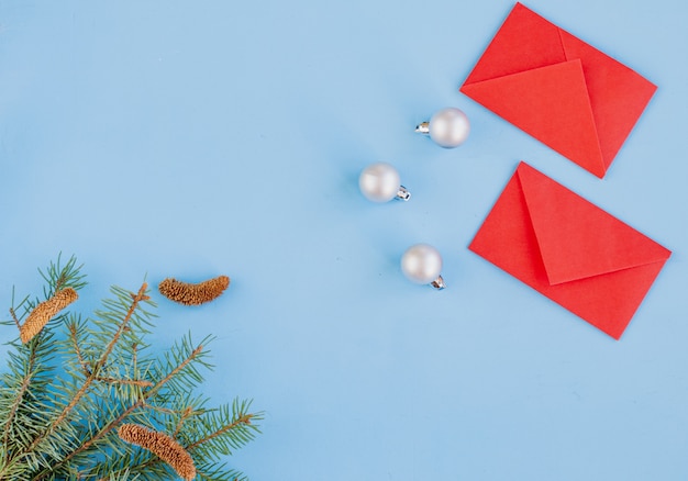 Chinees nieuwjaar en nieuw maanjaar. Takken van vuren, rode enveloppen met zakgeld. Kerstmisdecoratie, kruiden op blauw. Vlakke positie, hoogste mening, copyspace