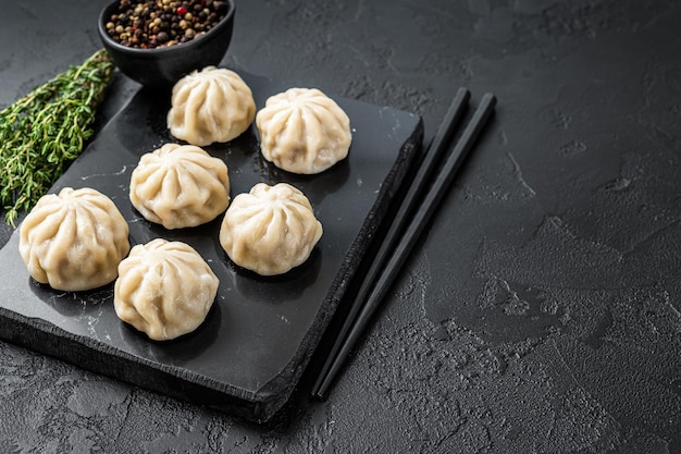 Chinese baozi dumplings op een marmeren bord. Zwarte achtergrond. Bovenaanzicht. Ruimte kopiëren.