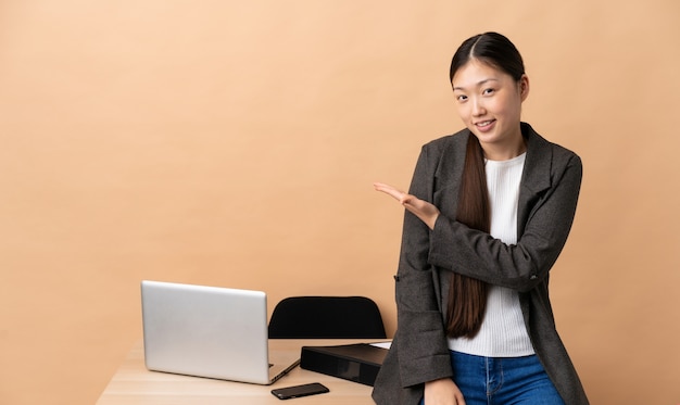 Chinese business woman in her workplace presenting an idea while looking smiling towards