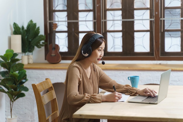 Chinese business woman wear headphones working with video call\
for customer service