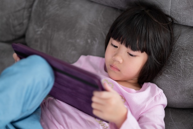 Chinese child addicted phone, asian girl playing smartphone, kid watching cartoon