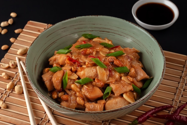 Chinese dish with chicken, chili, peanuts, sauces, and onions