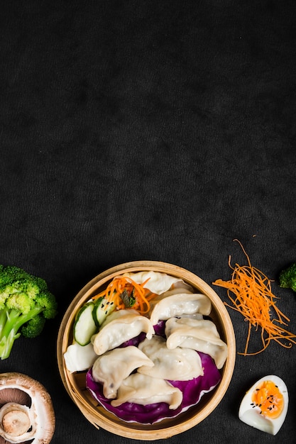 Chinese dumplings geserveerd op de traditionele steamer met salade en gekookte eieren