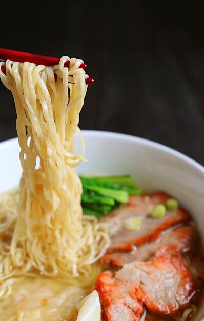 Chinese Egg Noodle Being Grabbed by Chopsticks