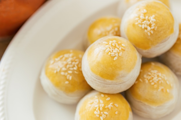 Chinese flaky pastry or mooncake filled sweet mung bean paste and salted egg yolk on white plate