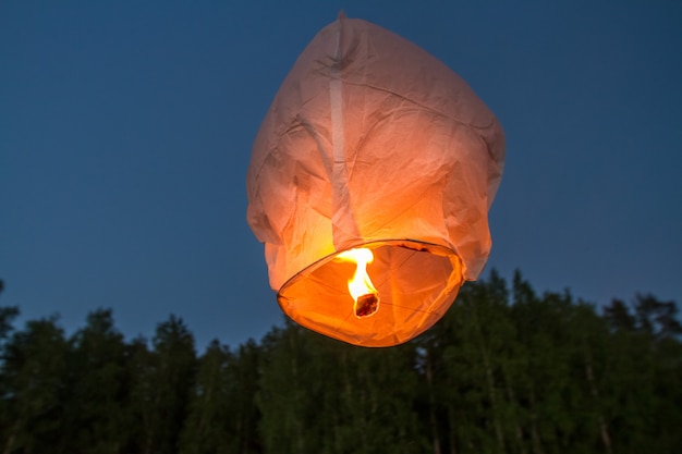 Chinese flying lanterns, flying over lake in dark