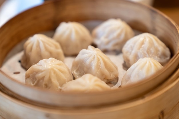 Cibo cinese caldo xiaolongbao cotto a vapore in cesto fumante di bambù