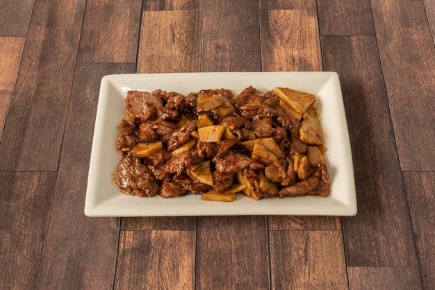 A Chinese food tray of chopped beef with bamboo and stewed mushrooms and oyster sauce