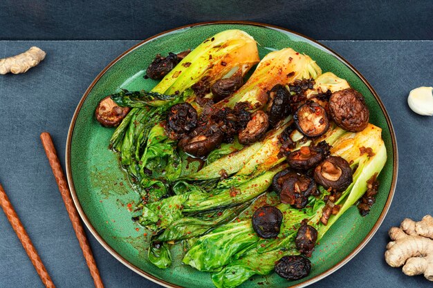 Chinese fried Pak Choi with shitake mushrooms and chopstick Asian vegan food