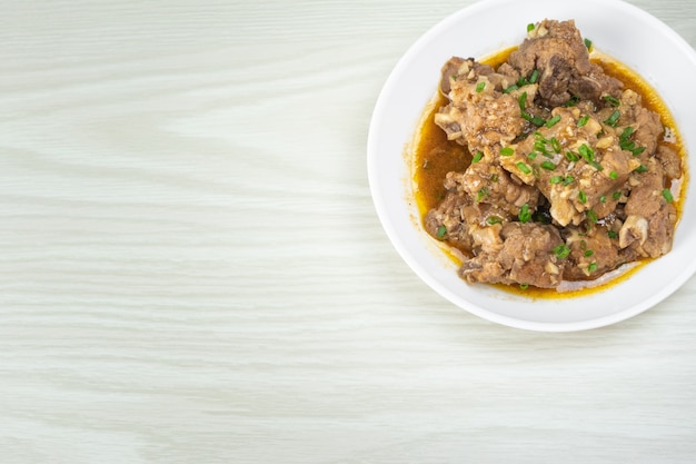Chinese gesmoorde varkensvlees spareribs met peper en knoflooksaus in witte plaat op de lijst