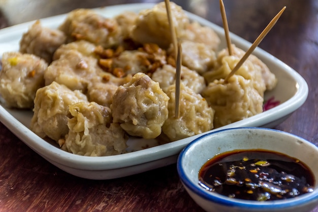 Chinese gestoomde dumplings (Dim Sum) met saus is een Chinees eten op houten tafel