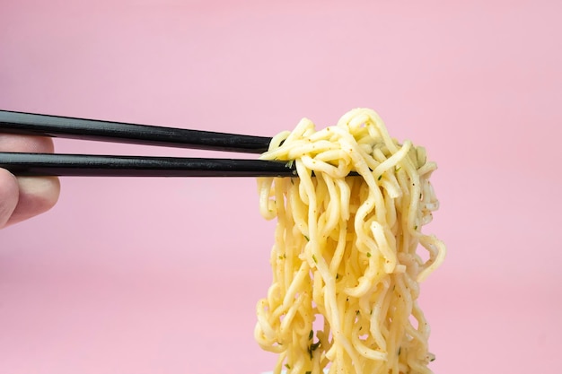 Chinese instant noodles Asian food White dish of noodles on an pink background fast cheap food