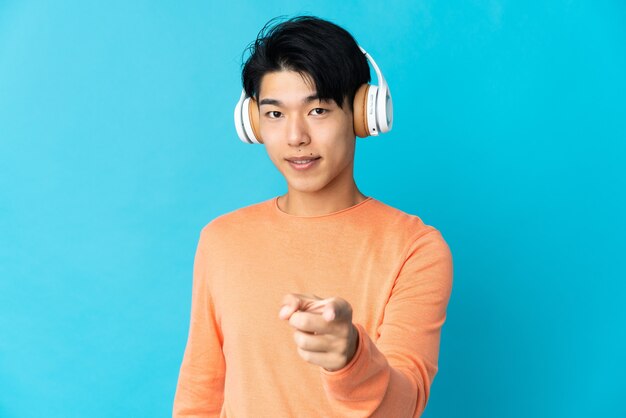 音楽を聴き、正面を指している孤立した空間上の中国人