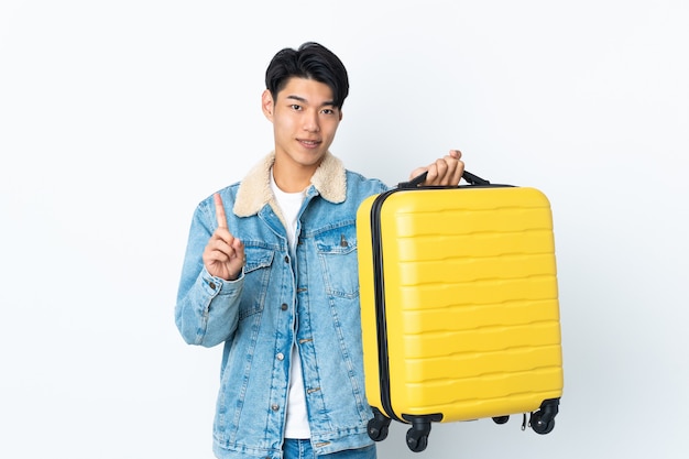 Китаец над изолированным пространством в отпуске с дорожным чемоданом и считает один