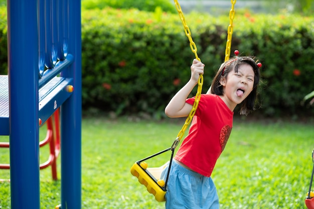 Chinese kinderen die schommel spelen, kinderen hebben plezier met de speeltuin, blij meisje