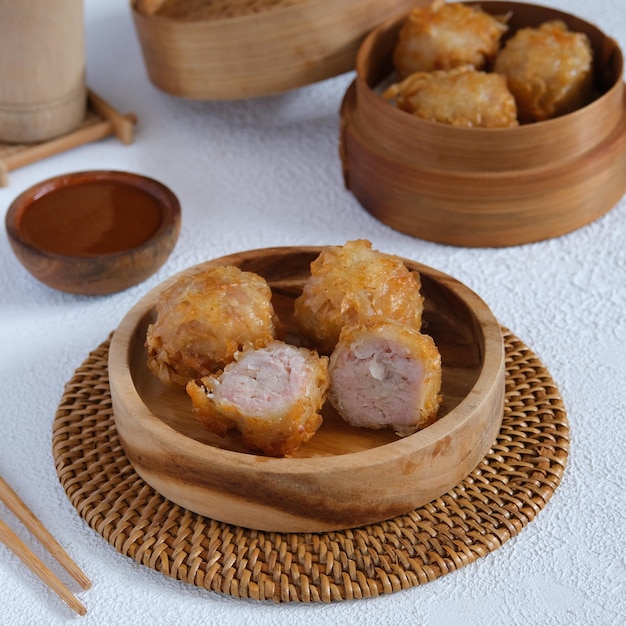 Chinese knoedel of dimsum op houten schotel met witte achtergrond