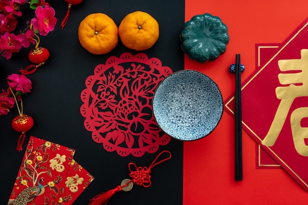 Photo chinese lunar new year decoration over red and black background flat lay dinning table concept