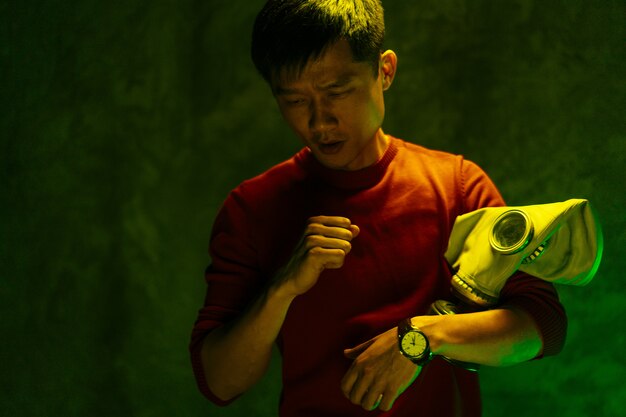 Chinese man holding respirator mask. Air pollution concept