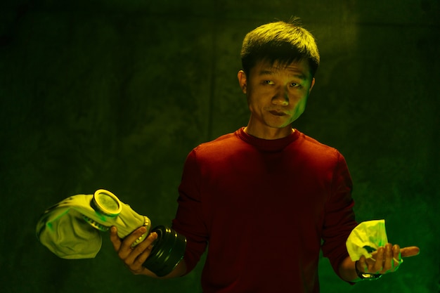 Китайский человек, держащий респиратор маску. Концепция загрязнения воздуха