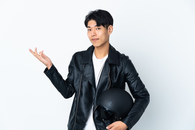Chinese man with a motorcycle helmet isolated on white background extending hands to the side for inviting to come