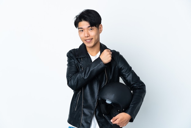 Chinese man with a motorcycle helmet isolated on white wall celebrating a victory