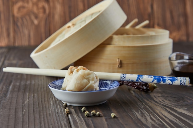 竹蒸し器に箸と点心を入れた中華肉団子蒸し料理。