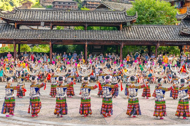 Photo the chinese miao women wearing traditional clothes and dancing in opera house of xijiang