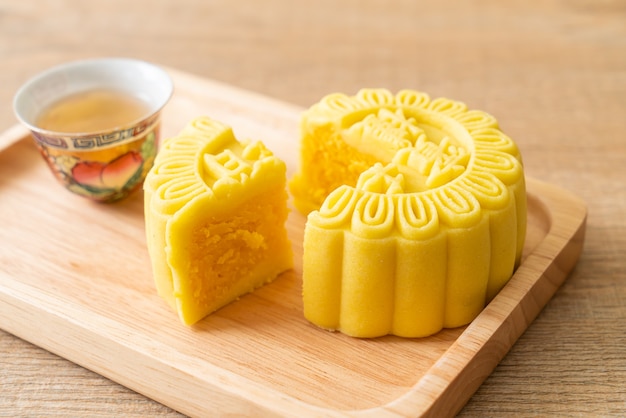 Chinese moon cake custard flavour with tea on wood plate