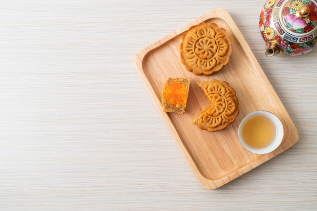 Chinese moon cake durian and egg yolk flavour with tea on wood plate