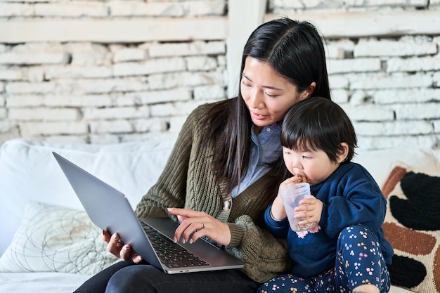 중국인 어머니와 유아가 노트북 화면에 미소 짓고 즐거운 시간