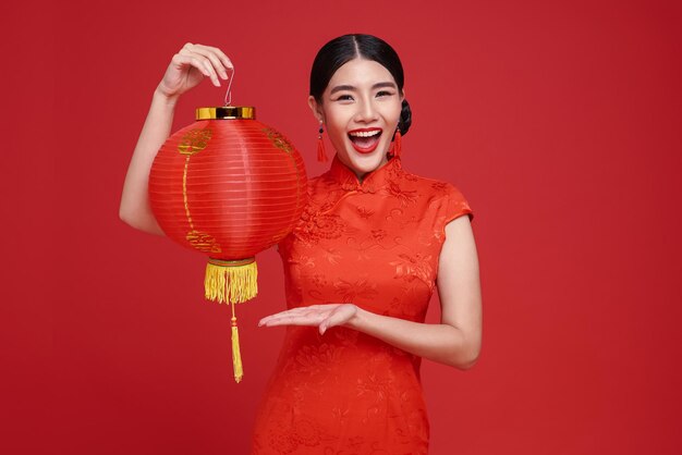 Chinese new year Asian woman wearing traditional cheongsam qipao dress holding Chinese lanterns