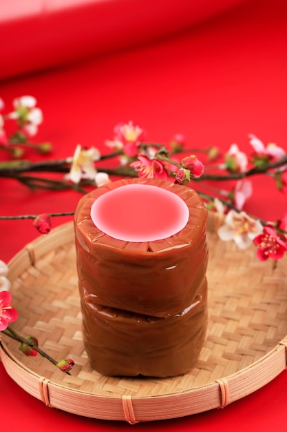 Chinese New Year Cake, Popular as Kue Keranjang or Dodol China in Indonesia. Served on Bamboo Plate, Imlek Flower Decoration