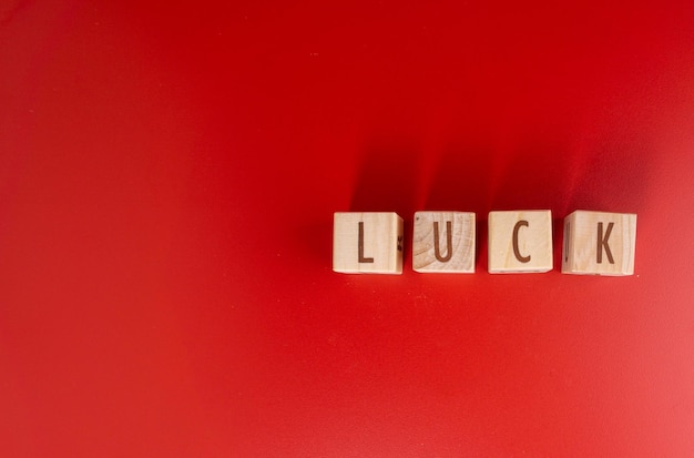 Chinese new year concept luck word written on wood block on red\
background isolated red